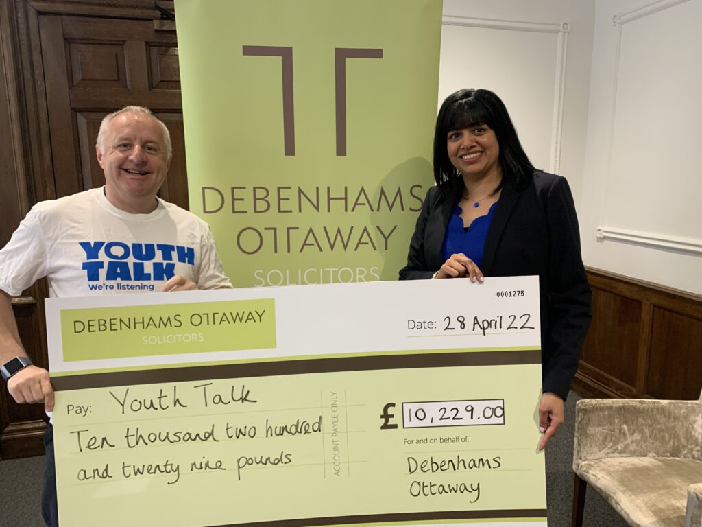 four-year partnership with Debenhams Ottaway CEO of Youth Talk holds a supersized cheque from Debenhams Ottaway