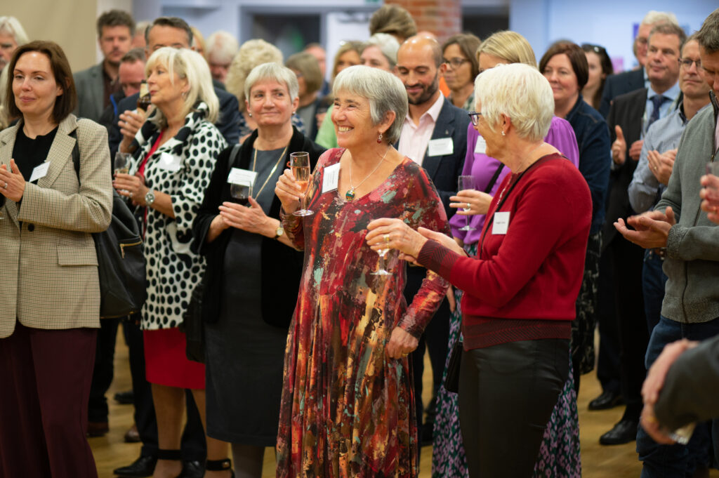 A crowd applaud Youth Talk's founder Dr Ida Fairbrain